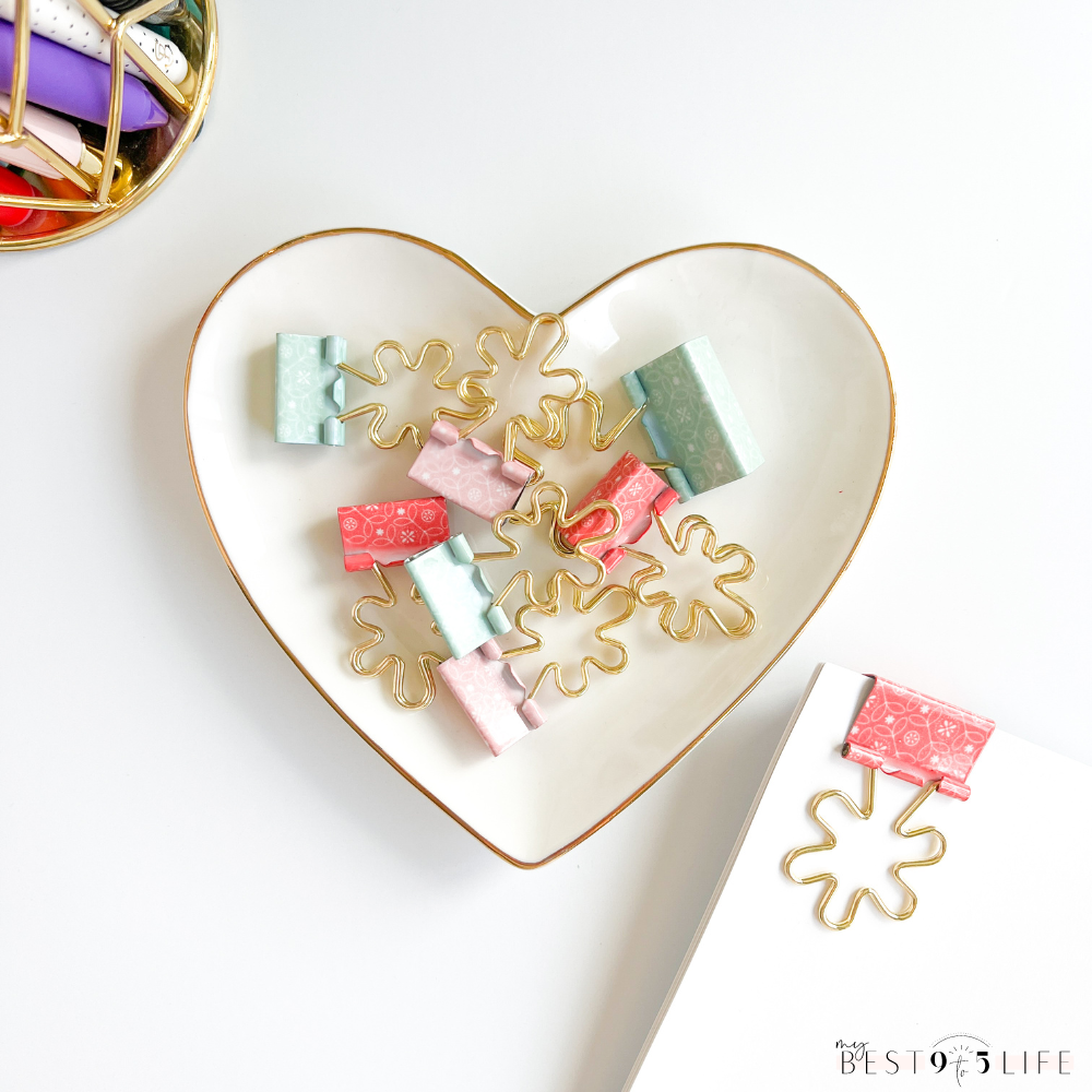 Image of flower shaped binder clips of varying colors and sizes in a heart shaped trinket tray