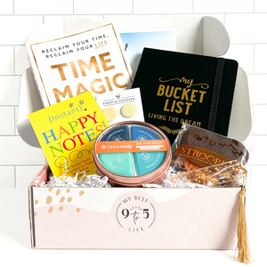 Image of My Best 9 to 5 Life's February 2024 Subscription Box unboxed showing contents inside: Time Magic book, bucket list journal, circle sticky notes, Instant Happy Notes, anti-phubbing phone blocker set, chocolate heart stroopie and gold flake bookmark